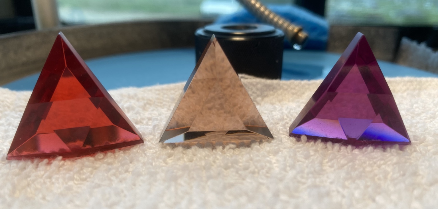 Three prototype artifacts laid out; geometric forms and materials visible